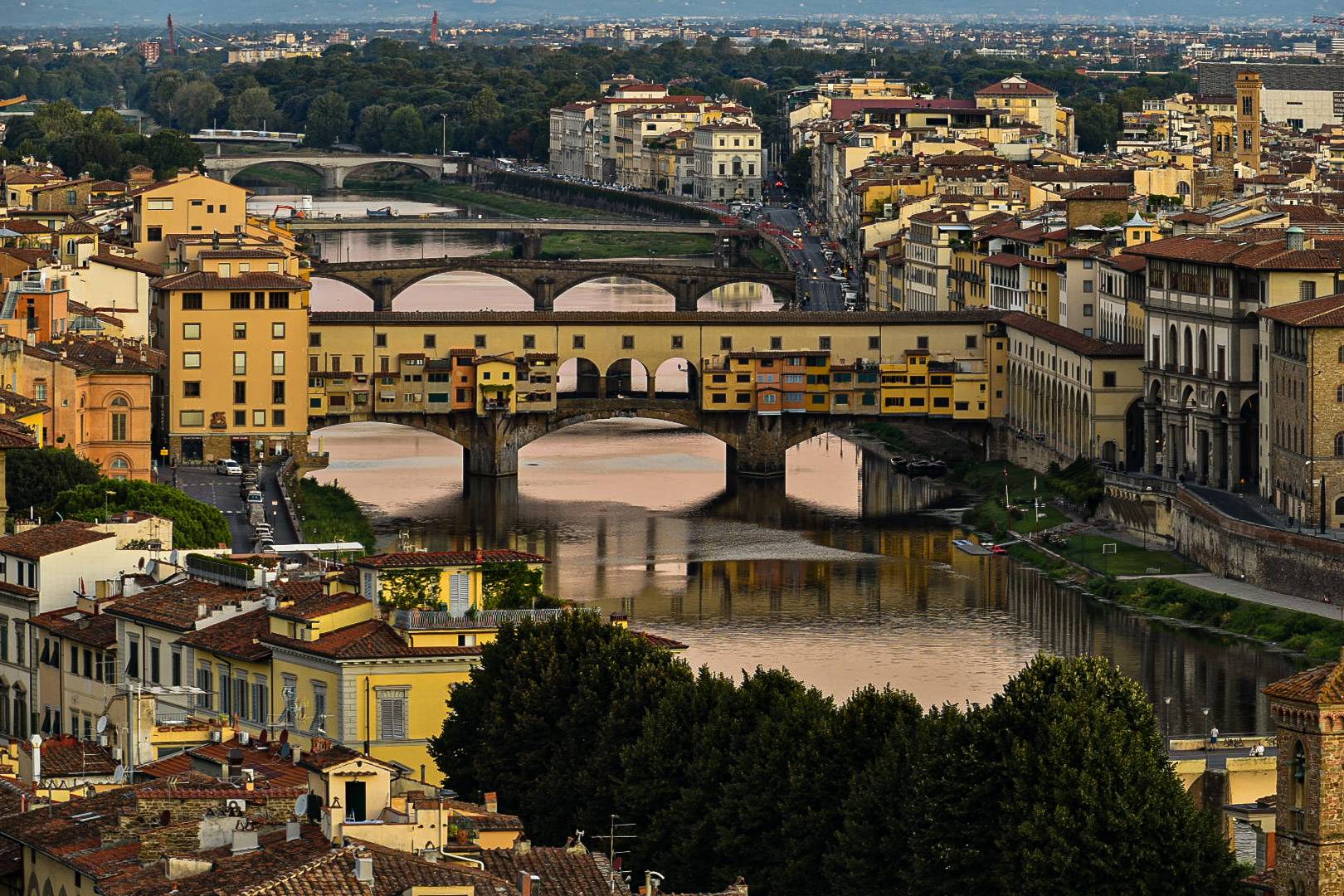 Sunrise shot of river Arno with Ponte Vecchio bridge in center shot